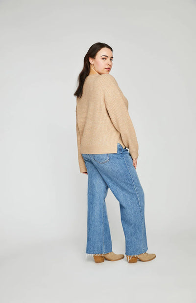 Curvy woman wearing a boxy tan sweater and jeans for fall.